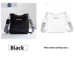 Détail du sac seau noir motif crocodile avec bandoulière tissée contrastée et boucle dorée