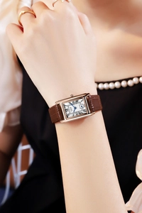 Detail view of GEDI vintage square watch with rose gold case and brown leather strap on wrist