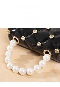 Close-up of black quilted jelly bag featuring sparkling diamonds and pearl handle strap