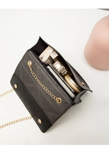 Internal view of black chain bag showing storage space for cosmetics and essentials