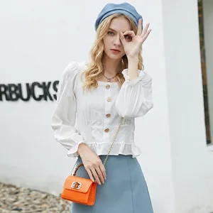 White puff sleeve square neck blouse styled with an orange crocodile pattern mini handbag