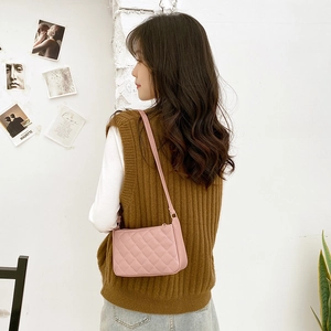 Pink quilted faux leather baguette underarm bag for women worn by a model