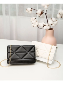 Detail of black and white rectangular crossbody bags with geometric quilting and gold chains