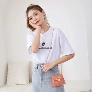 Pink mini jelly handbag with rivets and gold chain strap worn by model against white background