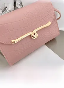 Detail of pink croc-embossed texture and golden heart-shaped metal twist lock closure