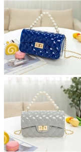 Detail of quilted jelly bag with pearl handle and metal gold chain strap close-up