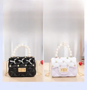 Close-up of mini quilted jelly bags in black and white with pearls and gold chains