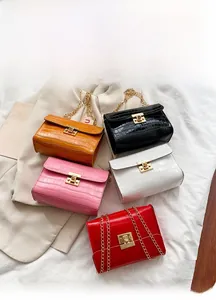 Five crocodile pattern crossbody bags in various colors with gold chain straps and locks