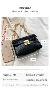 Detail view of black crocodile pattern crossbody bag with golden square lock and chain strap