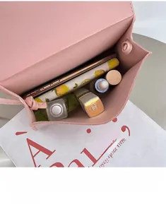 Internal view of a small pink crossbody bag showing phone, lipstick, and cosmetics storage
