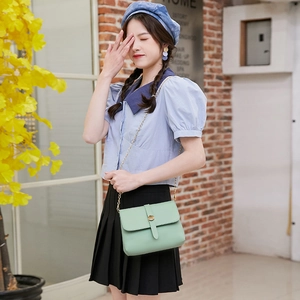 Mint green PU leather crossbody chain bag with a gold buckle shown on a model