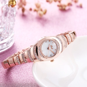 Elegant rose gold women's watch with crystals and white pearl dial on a pink background