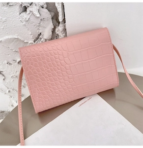 Detail shot of the pink crocodile texture embossed leather on a mini crossbody square bag
