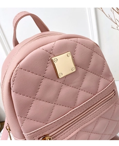 Detail of pink quilted PU leather mini backpack with golden metal hardware and front pocket