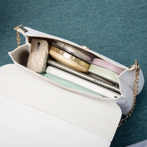 White faux leather chain crossbody bag for women showing interior storage capacity