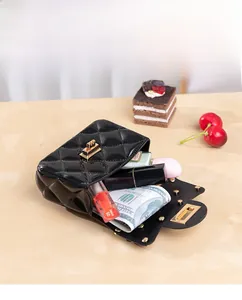 Detail of open black quilted mini bag showing interior space for lipstick and perfume