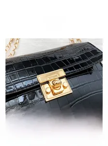 Close-up of black crocodile pattern leather texture and gold metal buckle hardware