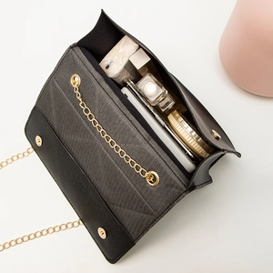 Black quilted crossbody chain bag showing internal capacity for phone and cosmetics