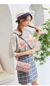 Pink crossbody bag featuring geometric grid stitching and a sporty graphic wide strap