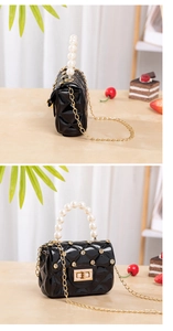 Close-up of black jelly bag with diamond studs, quilted pattern and pearl handle