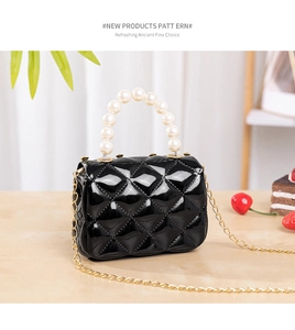 Detail of black quilted jelly bag with pearl handle and gold chain on wooden table