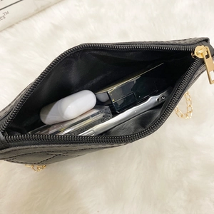 Quilted black crossbody camera bag with gold chain strap and interior storage view