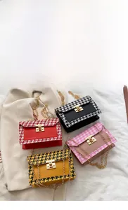 Detail view of colorful houndstooth crossbody bags with gold metal locks and chain straps