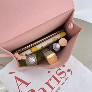 Pink faux leather mini crossbody bag showing internal space for a smartphone and lipstick
