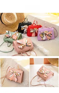 Detail of crocodile pattern mini bags with silk scarves and metal lock closure