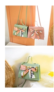 Close-up of crocodile pattern mini handbags with decorative silk scarf bows and gold locks