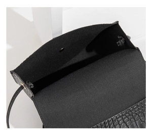 Dettaglio della borsa nera con trama a coccodrillo che mostra la chiusura magnetica