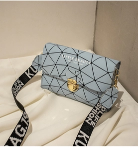 Detail of the light blue handbag with geometric patterns and golden buckle closure