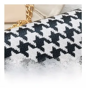 Detail of houndstooth crossbody bag featuring premium fabric texture and gold chain strap