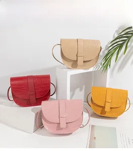 Dettaglio di quattro borse a sella con motivo coccodrillo in beige, rosso, rosa e giallo