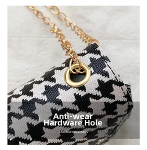 Detail of wear-resistant metal eyelet and gold chain on houndstooth fashion bag