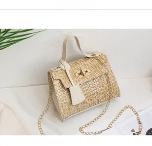 Close-up of beige woven straw handbag featuring V-pattern texture and gold metal turn-lock