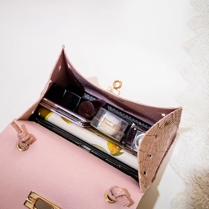 Pink crocodile pattern mini handbag with scarf detail and spacious interior compartment
