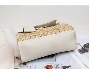 Detail of straw woven crossbody bag showing V-shape texture and gold metal lock
