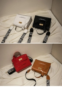 Detail of four patent leather handbags with metal locks and wide lettered shoulder straps