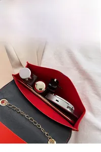 Vue intérieure d'un petit sac à chaîne contenant un téléphone, rouge à lèvres et parfum