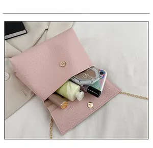 Sac bandoulière en cuir rose grainé montrant la capacité pour le maquillage quotidien