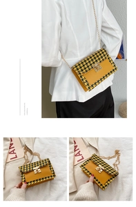 Detail of yellow houndstooth pattern crossbody bag with gold rotating lock and chain