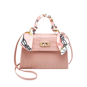 Pink crocodile pattern mini handbag with decorative scarf and golden buckle on white background