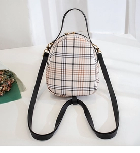 Detail view of stylish checkered mini backpack with golden zippers and black leather straps