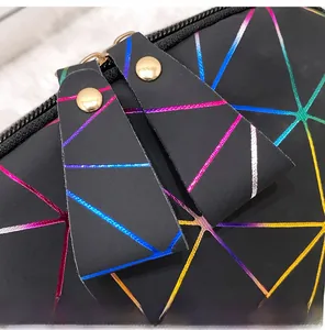 Detail of holographic geometric pattern on handbag with premium gold metal zippers