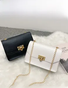 Dettaglio di mini borse a catena chic in bianco e nero con chiusure quadrate dorate