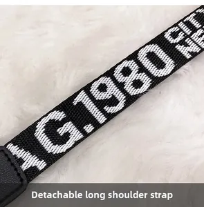 Macro shot of detachable black and white woven shoulder strap with G.1980 lettering