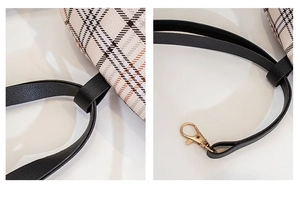 Close-up of beige plaid fabric stitching and gold lobster clasp on small backpack