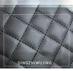 Close-up of black quilted leather texture with diamond stitching and litchi pattern