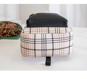 Detail view of the small checkered bag bottom featuring white fabric and black lychee leather